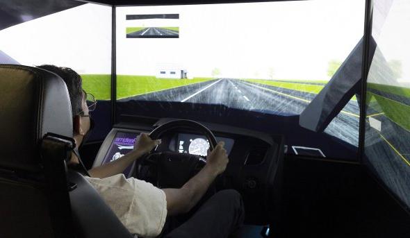 A student tests out a driving simulator. 